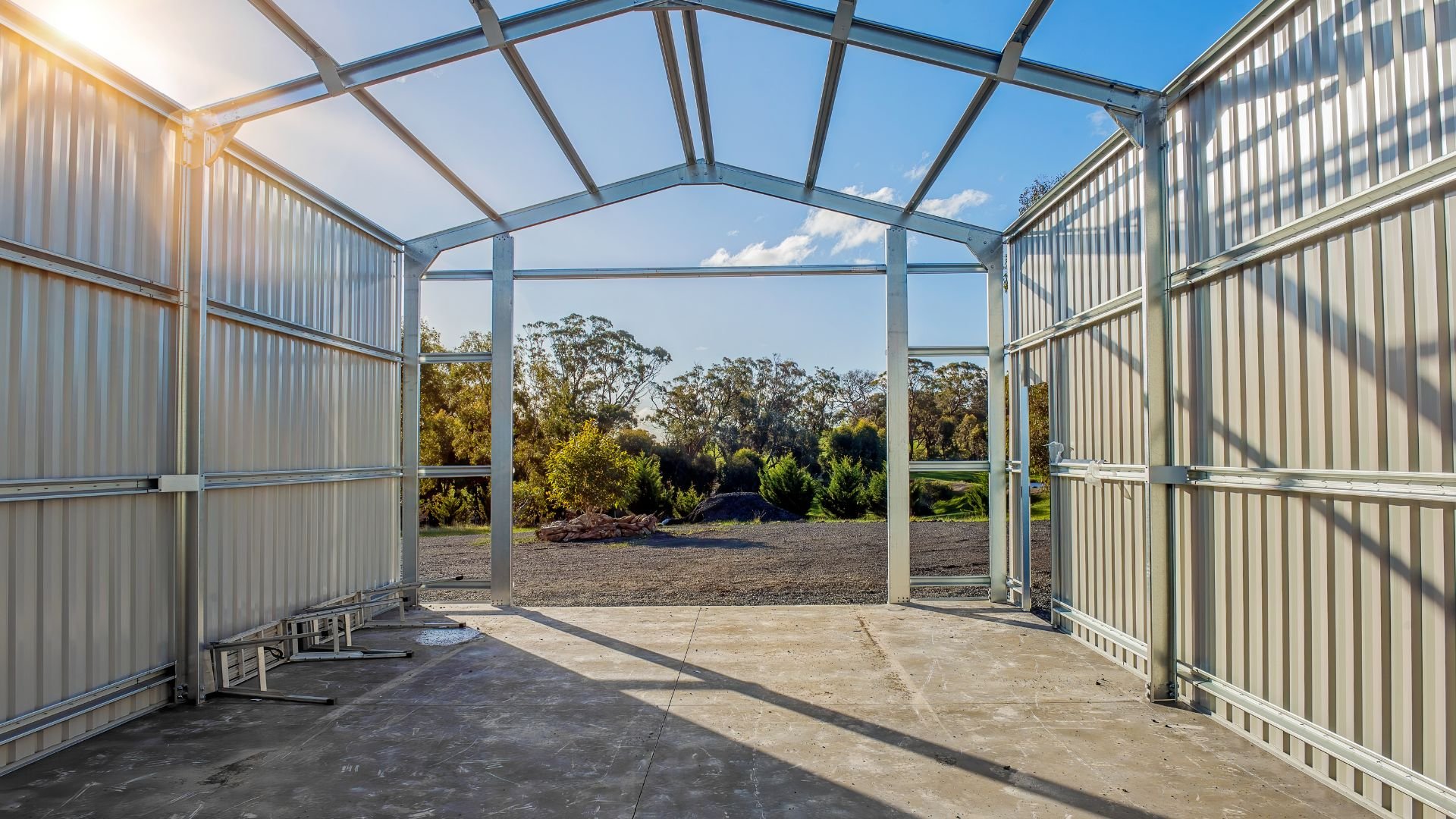 Metal shed with open doors revealing trees and landscaped outdoor area