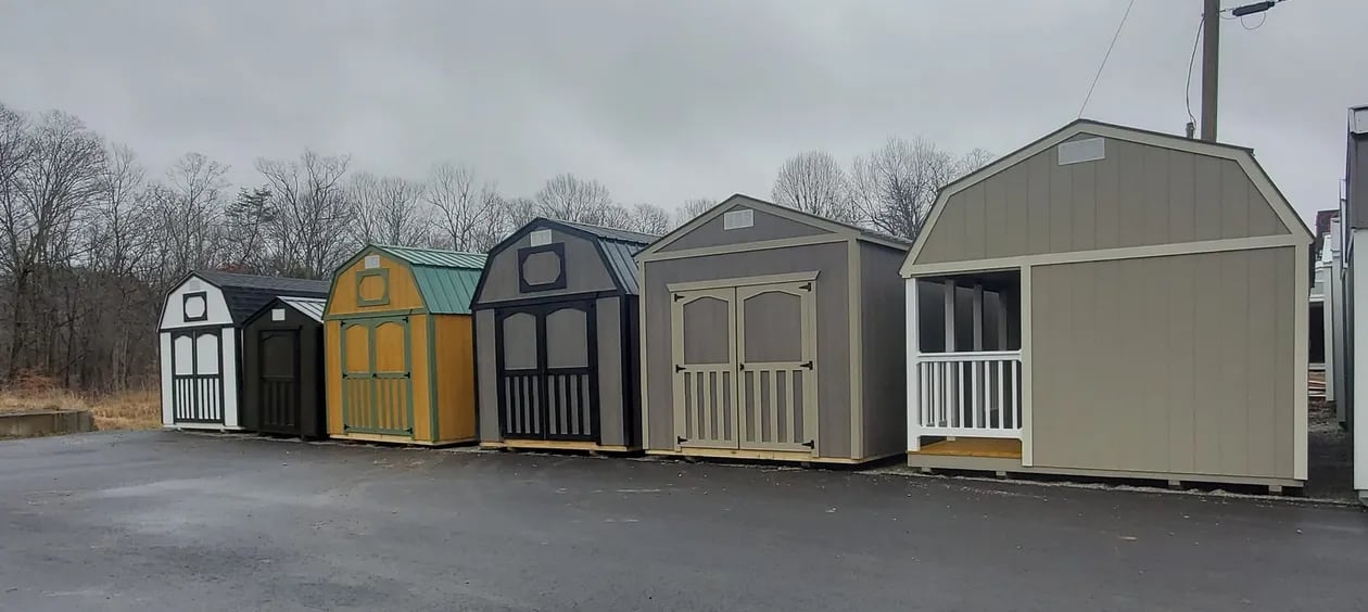 Several colorful storage sheds lined up in parking lot on cloudy day